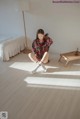 A woman sitting on the floor in a bedroom.