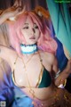 A woman with pink hair wearing a bikini and a cat ears headband.