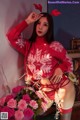 A woman in a red sweater and stockings posing for a picture.