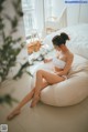 A woman sitting on a bean bag chair in a bedroom.