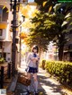 A woman in a school uniform is walking down the street.