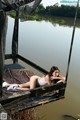 A woman laying on a dock next to a body of water.