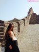 A woman leaning against a wall on the Great Wall of China.