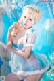 A woman dressed as Elsa from Frozen is posing for a picture.