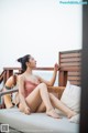 A woman in a pink bathing suit sitting on a couch.