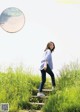 A woman standing on a set of stairs in a grassy field.