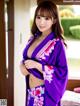 A woman in a purple kimono posing for the camera.