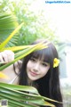 A young woman with a yellow flower in her hair.