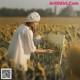 A woman in a field of sunflowers painting a picture.