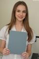 A young woman holding a blue folder in her hands.