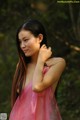 A woman in a pink dress posing for a picture.