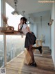 A woman sitting on top of a wooden stool in a room.