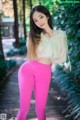 A woman in bright pink leggings posing for a picture.