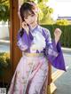 A woman in a purple and white hanbok posing for a picture.