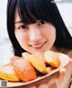 A young woman holding a plate of fried food.