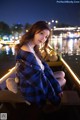 A woman sitting on a boat with a teddy bear.