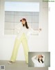 A woman in a white shirt and yellow pants posing for a magazine.